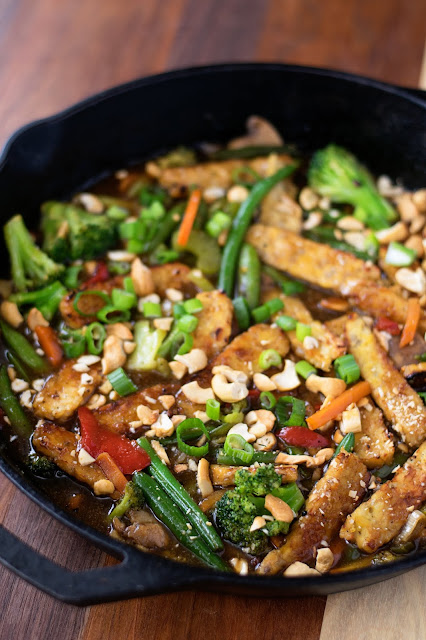 The finished pan of Vegan Tempeh Stir Fry topped with sliced green onion and chopped cashews. 