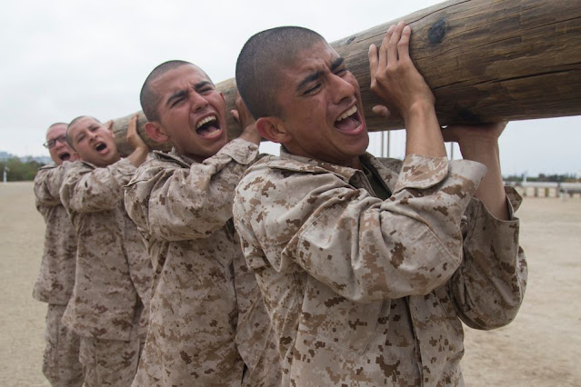 Recruits with India Company, 3rd Recruit Training Battalion, lift a log during log drills at Marine Corps Recruit Depot