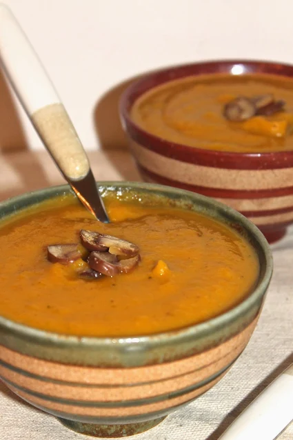 Bowl of soup with sliced chestnuts on top.