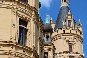 Turrets of a castle under a bright blue sky.