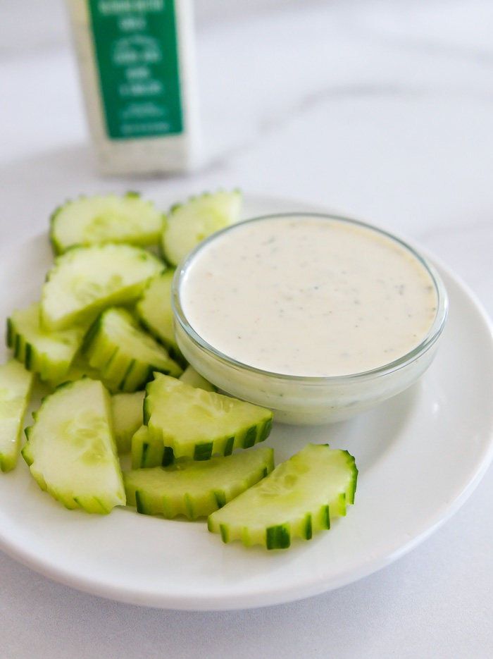 Trader Joe's Vegan Creamy Dill Dressing in a bowl for dipping with sliced cucumbers