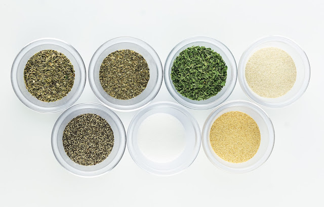 overhead shot of Spaghetti Seasoning ingredients in clear bowls on a white background.