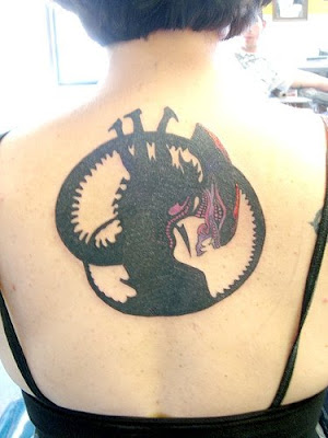 sexy girl showing design alien tattoo on her back body