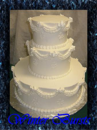 Wedding cake is covered with buttercream icing and is decorated with swags 