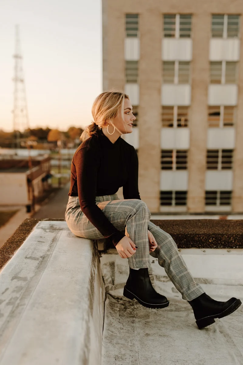 a beautiful woman in a fall outfit posing on the street