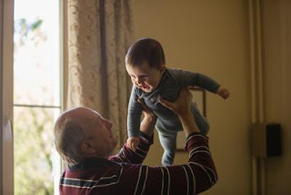 赤子を抱く老人性難聴の男性の写真