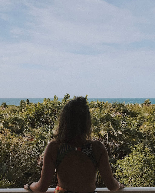 eu a olhar uma praia, em Cuba, com um cenário verdejante à minha frente e o mar, ao fundo