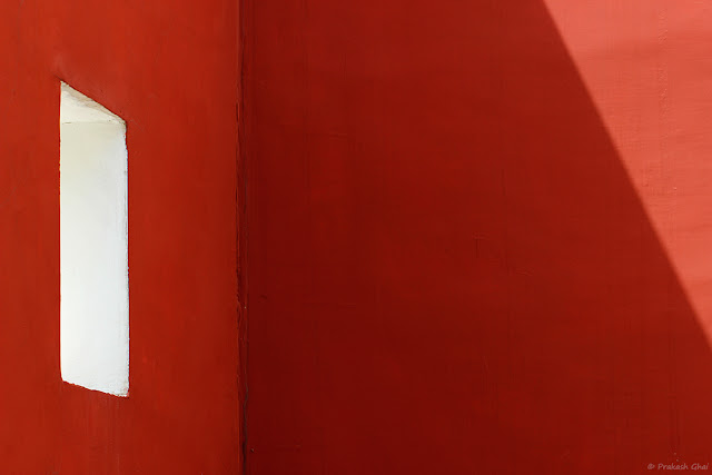 A Minimalist Photograph of a Red Wall with a White Rectangle and a Triangle made by Light, shot at Jawahar Kala Kendra - Jaipur 