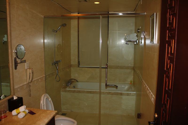 Marble-tiled bathroom, marble tub and shower with glass doors. title=