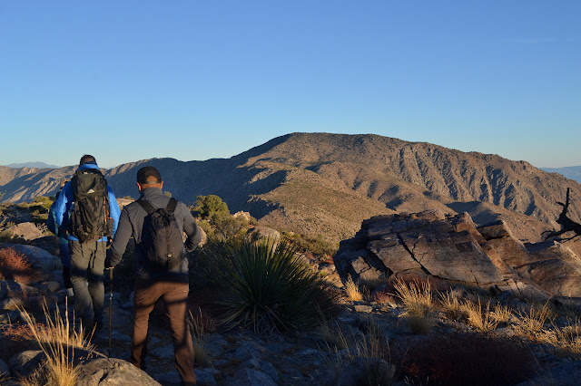 three hikers starting down off Villager Peak with Rabbit in the distance