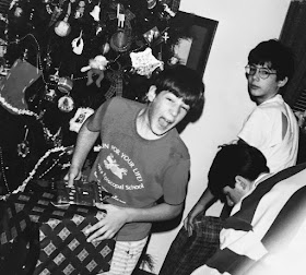 A scanned family photograph of three Roselli brothers opening their gifts one Christmas morning (ca. 1995)