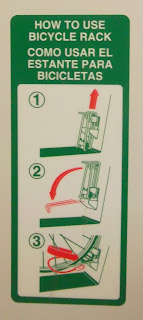 Instructional sign displaying how to secure lower wheel of bicycle in SMART Train bike-storage compartment