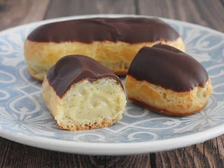 two mini eclairs on a blue and white plate