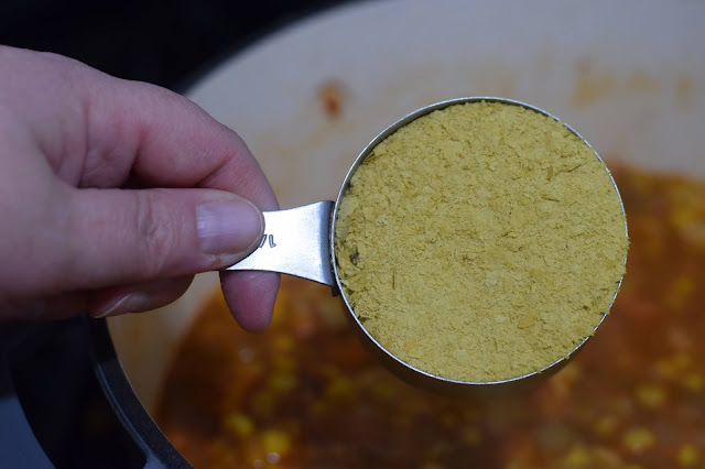 Nutritional yeast being added tot he pot.