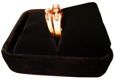 An engagement ring and wedding band in black velvet box.