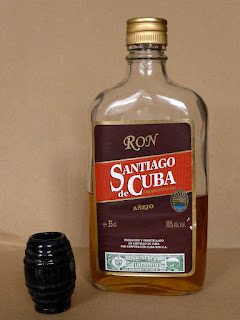 Rum der Marke Santiago de Cuba aus dem Museo de Ron. Halbvolle Flasche, davor ein Schnapsbecher.