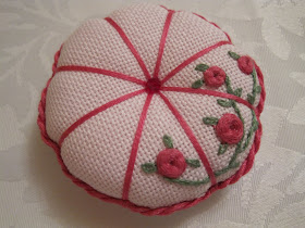 Round embroidered pin cushion decorated with pink roses 