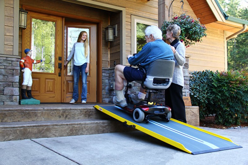 Man in wheelchair on ramp in front of the house