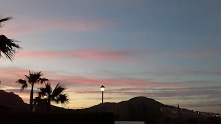 a gorgeous pink sunset over the mountains outside