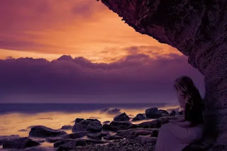 A girl on the beach under the cave seeing the sunset- sad girl dp