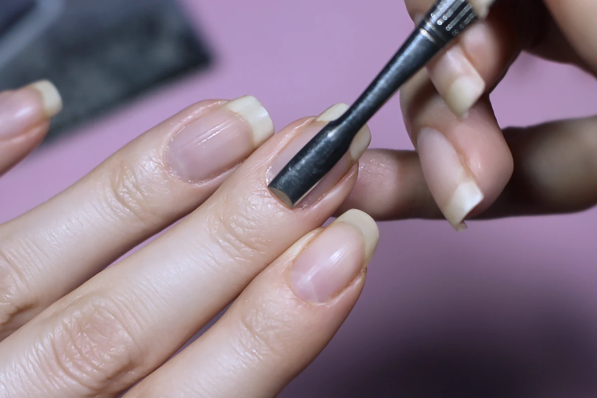 a close-up of woman's nails showing a process cuticle pushing