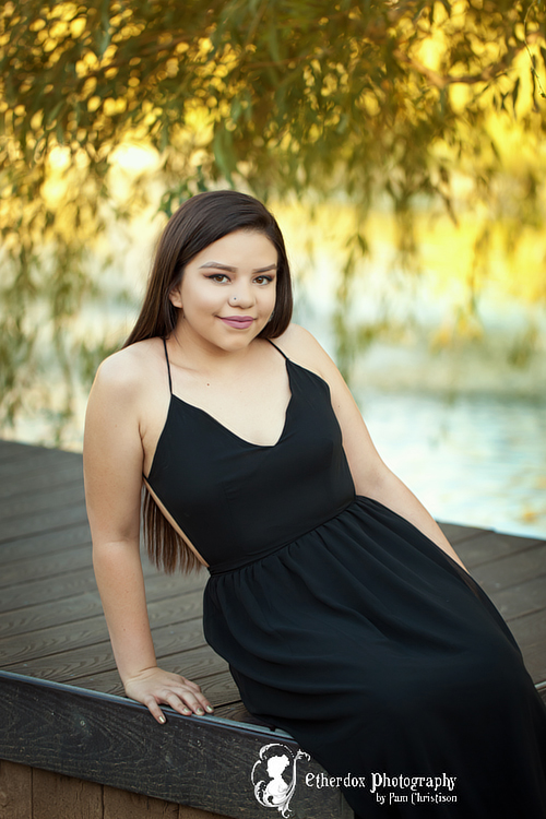 Professional photograph of an Atrisco high school senior on top at the UNM Duck Pond Albuquerque