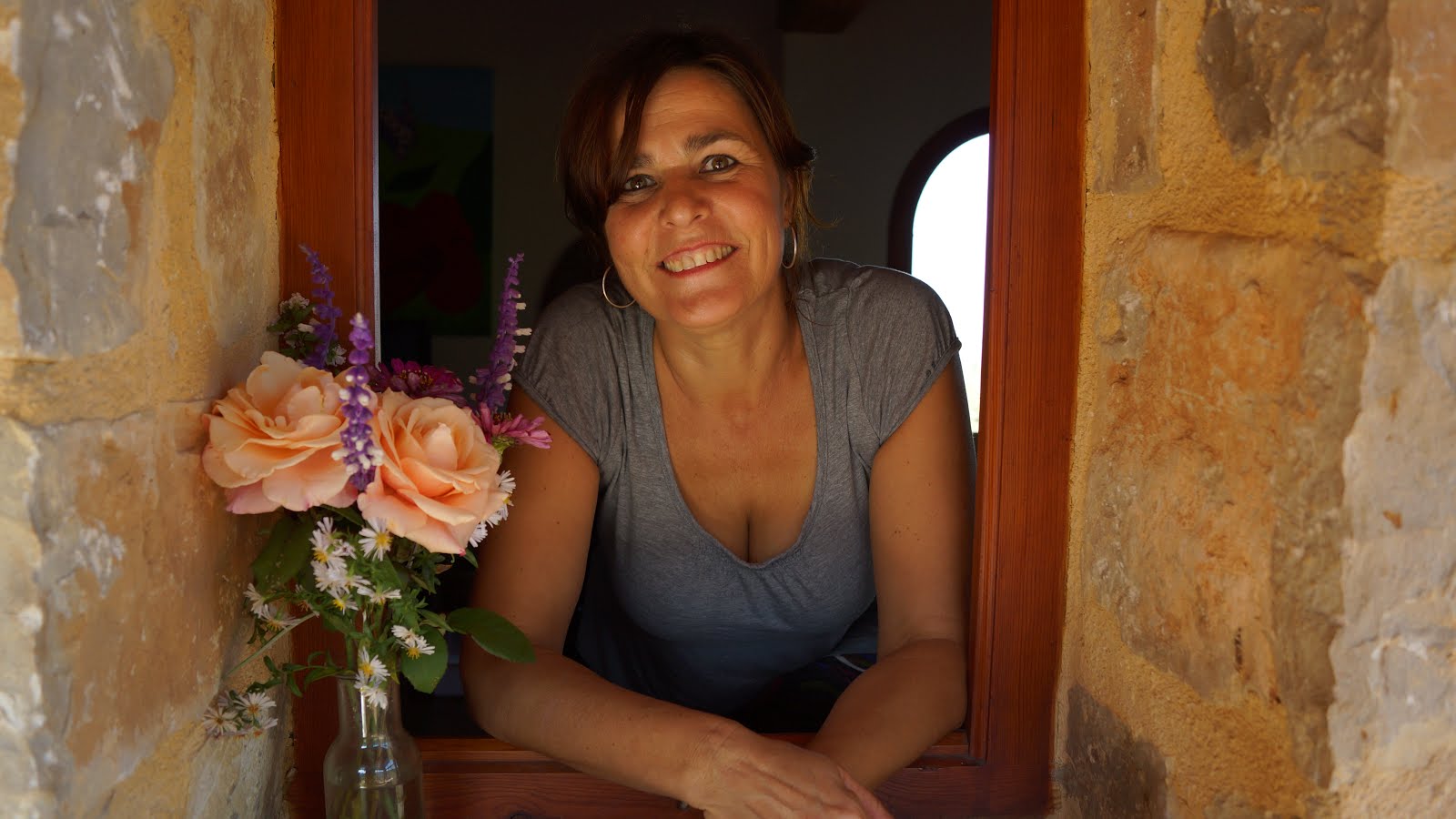 anna en la ventana con unas flores