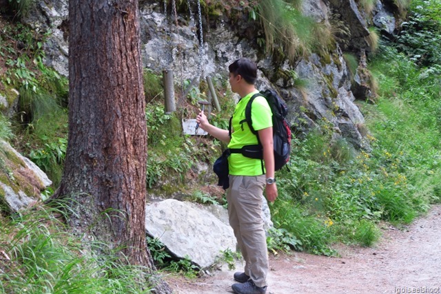 Trying out the metallophone, hung from a tree. Along the AHV Weg at Zermatt.