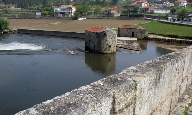 moinhos de água na margem de um rio