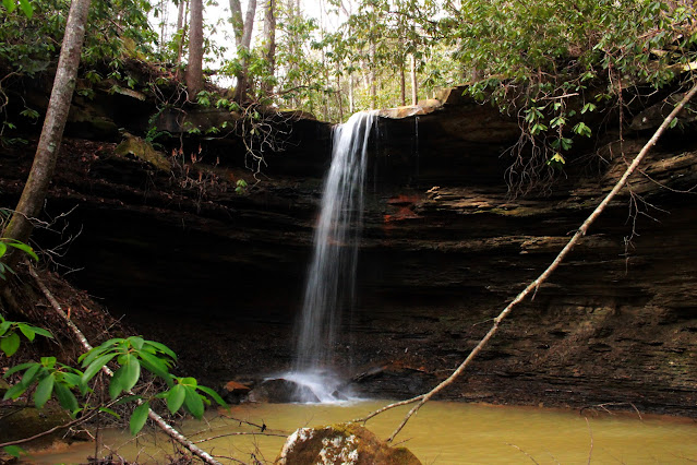 Slender white waterfall in Winter with dark rocks