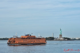 A Staten Island Ferry sails past the Statue of Liberty. Travel photography by Kent Johnson.