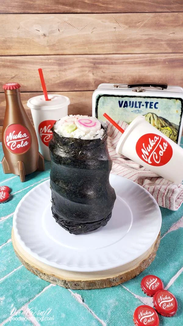 Giant gulper stuffed foot recreated by making enormous sushi roll sitting on paper plate near nuka cola and vault-tec lunchbox