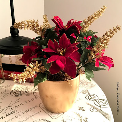 gold spray painted flower pot with faux berries, twigs and flowers