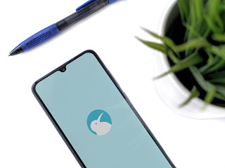 Kiwi, layout moderno onde aparece um celular e uma caneta em uma mesa, no celular há o logo do navegador em destaque