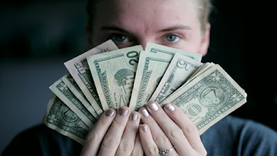 Currency notes arranged and held out in fan shape.