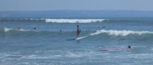 A surfer is surfing on a wave in Canggu Beach, Bali.