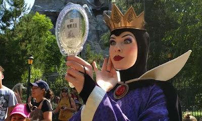 Actriz que interpreta a la Reina Malvada de Blancanieves en Disneyland, mirándose en un espejo