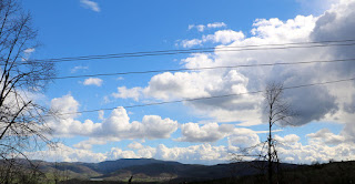 Some fluffy looking clouds, with a storm bubbling up as well