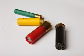 Four shotgun shells of different gauges
