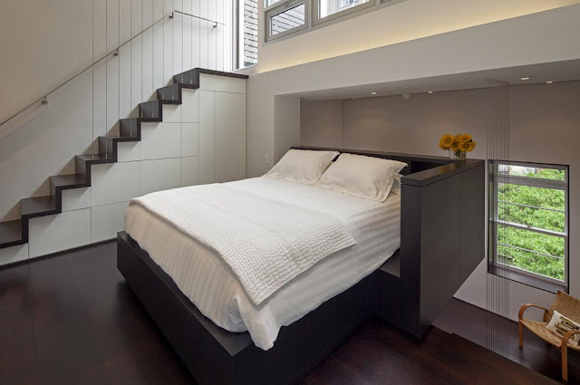 Modern king sized bed by the staircase