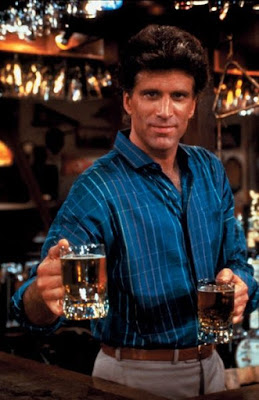 Young Ted Danson circa Cheers, holding out glasses of beer
