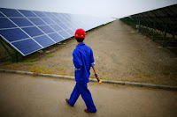 A worker inspects solar panels at a solar farm in Dunhuang, 950km (590 miles) northwest of Lanzhou, Gansu Province in this September 16, 2013 file photo. (Credit: Reuters/Carlos Barria/Files) Click to Enlarge.