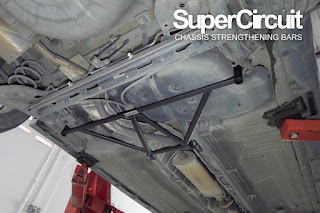 The rear chassis of the Nissan Latio with the SUPERCIRCUIT REAR LOWER BRACE installed.