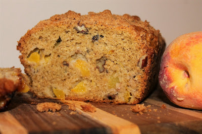 Side view of a cut peach and pecan streusel bread.