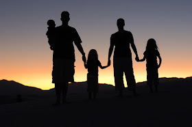 silhouettes of family holding hands 