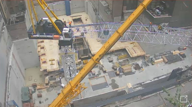 Photo of crane arm being connected to the crane