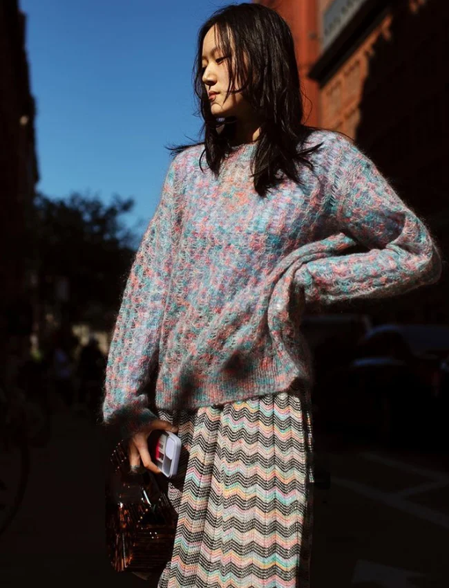 a young woman wearing steet style inspired look for fall/winter and posing on a street