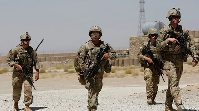 In this 2018 photo, US soldiers walk past a building in Logar Province, Afghanistan.