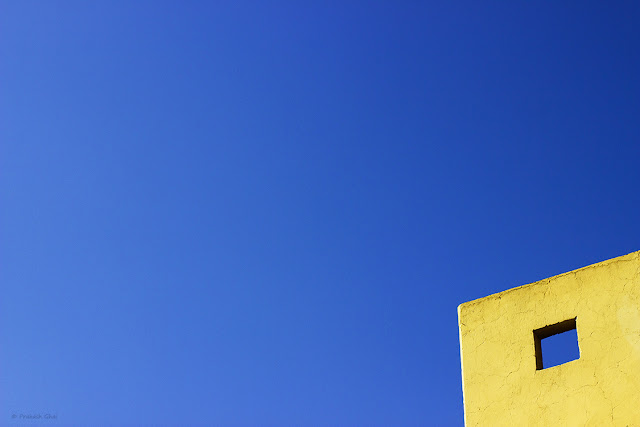 A Lookup Minimalist Photo of a Blue Square within a Yellow Wall.
