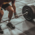 Person holding black and silver steel barbell